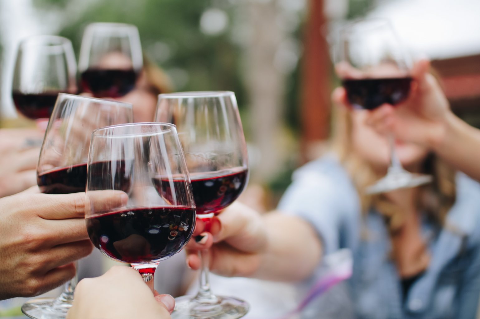 People cheers with red wine glasses