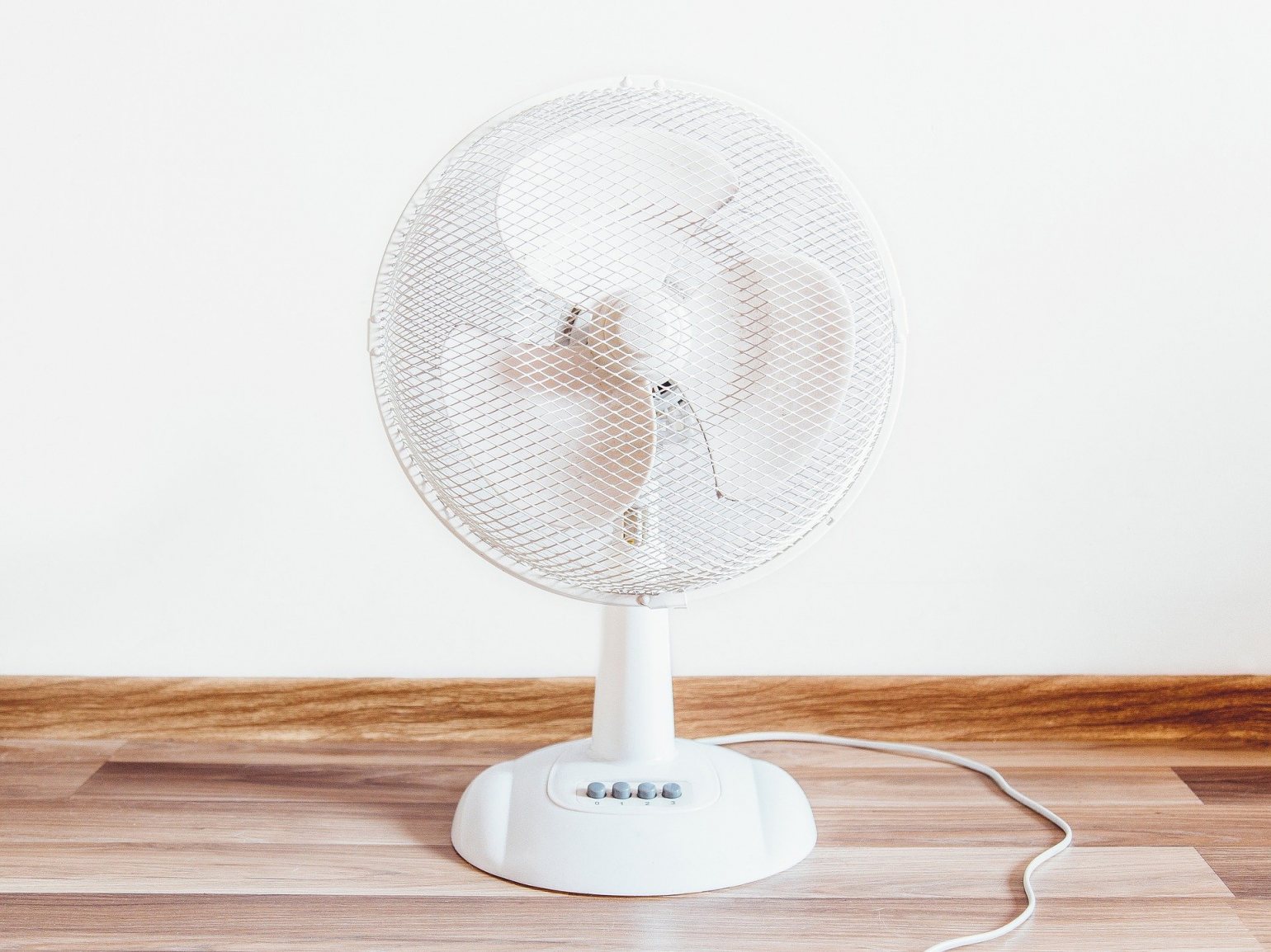 white fan on a wooden desk