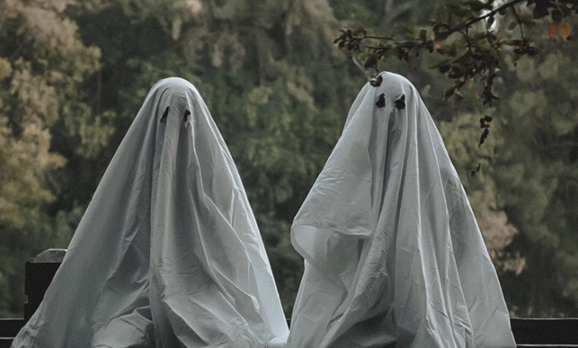 Two people in Halloween Ghost trick or treat costumes